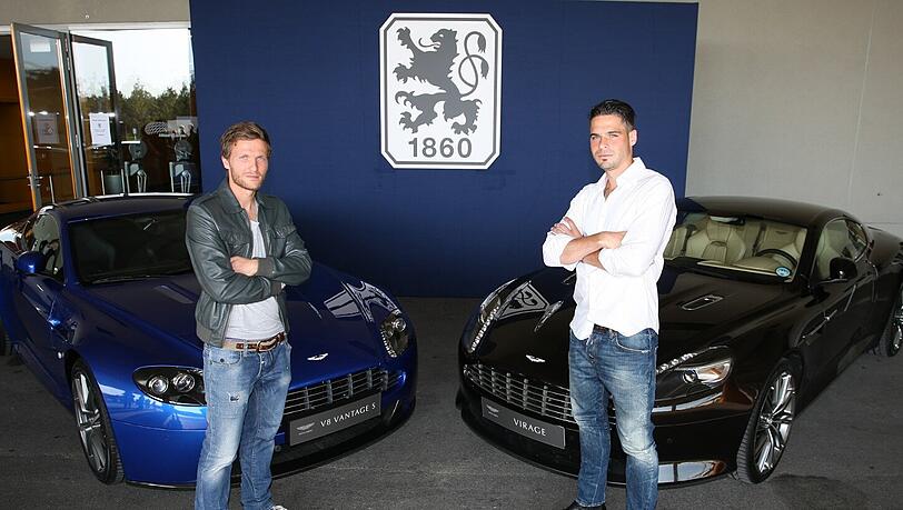 Die Löwen-Profis Benny Lauth (l.) und Stefan Buck posieren vor zwei Aston-Martin-Sportwagen. Die Marke soll auch nächste Saison noch auf der Löwen-Brust prangen. Die Löwen-Profis Benny Lauth (l.) und Stefan Buck posieren vor zwei Aston-Martin-Sportwagen. Die Marke soll auch nächste Saison noch auf der Löwen-Brust prangen.