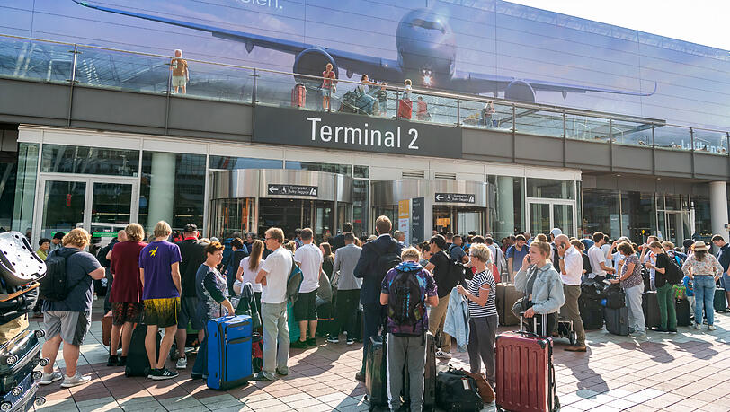 Passagiere stehen vor dem gesperrten Terminal 2 am Flughafen München. Passagiere stehen vor dem gesperrten Terminal 2 am Flughafen München.