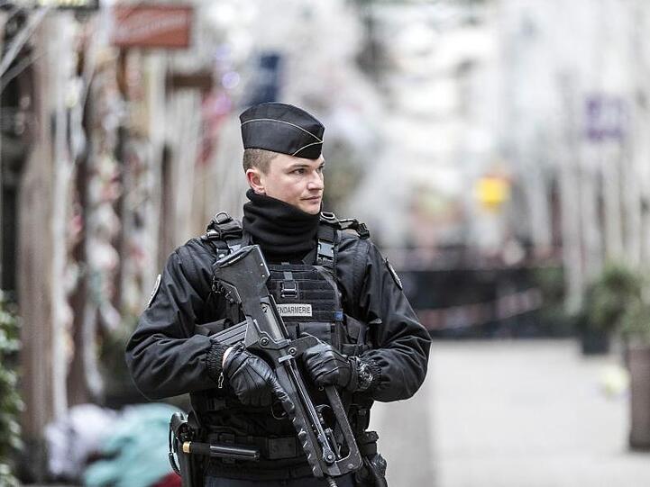 Ein Polizist steht nach einem Angriff in der Gegend des Straßburger Weihnachtsmarkts vor dem Tatort.