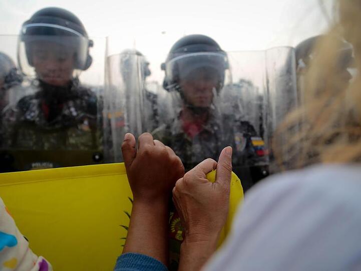 Demonstranten stehen vor einer Reihe venezolanischen Sicherheitskräfte an der Brücke Simon Bolivar.