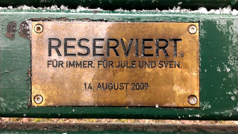 Im Englischen Garten und Nymphenburger Schlosspark haben Münchner tausende Plaketten mit Widmungen auf Parkbänken angebracht.