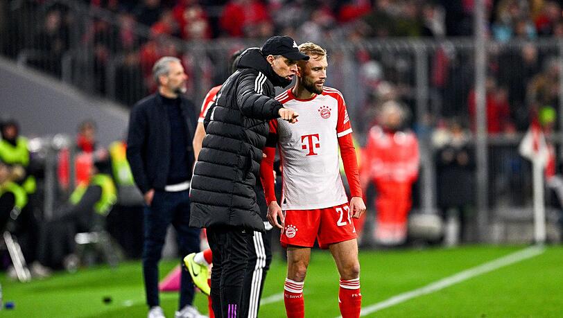 Trainer Thomas Tuchel von München (l) gibt Konrad Laimer taktische Anweisungen mit.