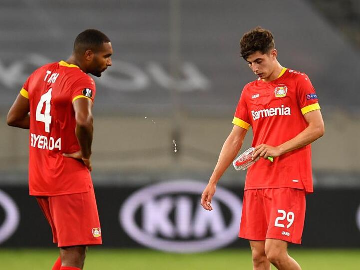 Leverkusens Jonathan Tah (l) und Kai Havertz stehen nach Abpfiff enttäuscht auf dem Platz.