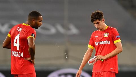 Leverkusens Jonathan Tah (l) und Kai Havertz stehen nach Abpfiff enttäuscht auf dem Platz.