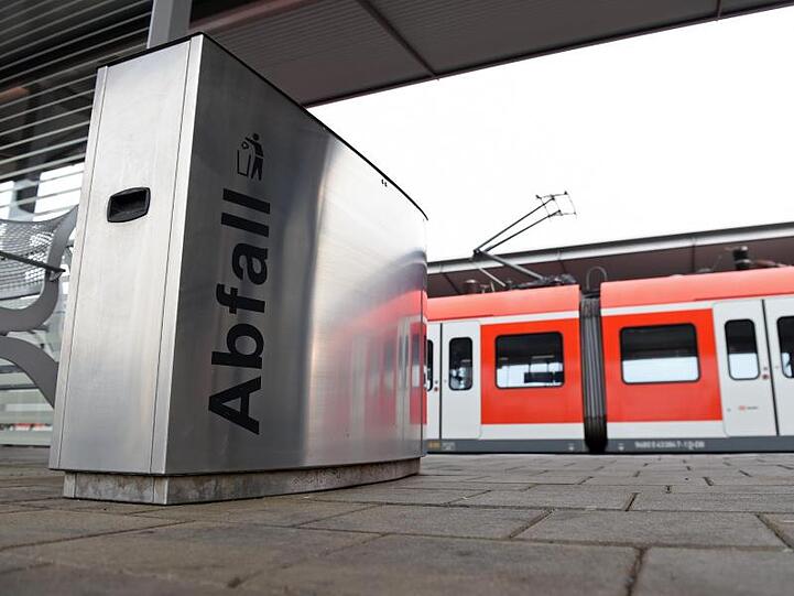 Eine S-Bahn steht am Pasinger Bahnhof hinter einem Abfalleimer.