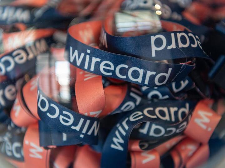 Umhängebändchen mit der Aufschrift "wirecard" liegen in einem Glasbehälter. Foto: Peter Kneffel/Archivbild