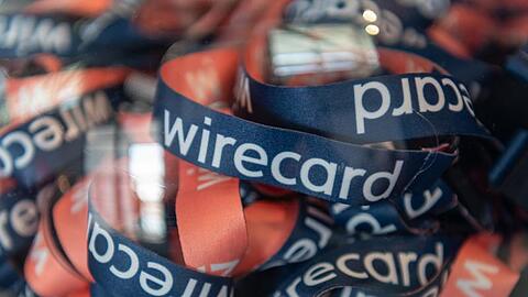 Umhängebändchen mit der Aufschrift "wirecard" liegen in einem Glasbehälter. Foto: Peter Kneffel/Archivbild