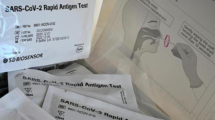 Schnelltests mit der Aufschrift "SARS-Cov-2 Rapid Antigen Test" liegen auf einem Tisch einer Grundschule zum Corona-Schnelltest bereit.