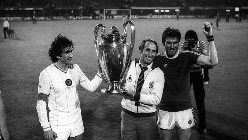 Der größte Triumph der Vereinsgeschichte: Villas Trainer Tony Barton (M.), Peter Withe (r.) und Dennis Mortimer mit dem Henkelpott. Der größte Triumph der Vereinsgeschichte: Villas Trainer Tony Barton (M.), Peter Withe (r.) und Dennis Mortimer mit dem Henkelpott.