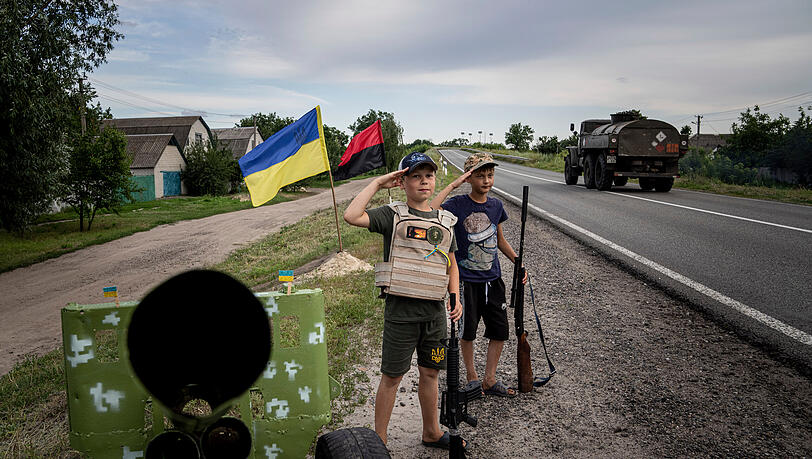Charkiw: Maksym und Andrii, beide elf Jahre alt, salutieren vor ukrainischen Soldaten mit Plastikgewehren - an einem selbstgebauten Kontrollpunkt an der Autobahn. Charkiw: Maksym und Andrii, beide elf Jahre alt, salutieren vor ukrainischen Soldaten mit Plastikgewehren - an einem selbstgebauten Kontrollpunkt an der Autobahn.