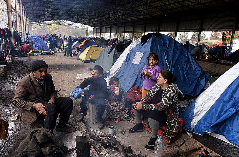 Hunderte Flüchtlinge aus dem Lager in Idomeni durchqueren einen reißenden Fluss auf griechischer Seite, um illegal nach Mazedonien zu gelangen.