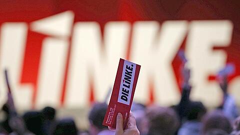 Delegierte der Linkspartei halten beim Parteitag in Bonn ihre Stimmkarte in die Luft.