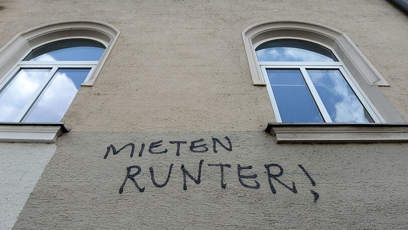 Münchner Aufschrei: "Mieten runter!", steht beinahe verzweifelt an der Fassade eines Hauses.