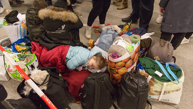 Ein kleines geflüchtetes Mädchen versucht am Berliner Hauptbahnhof zu schlafen. Ein kleines geflüchtetes Mädchen versucht am Berliner Hauptbahnhof zu schlafen.