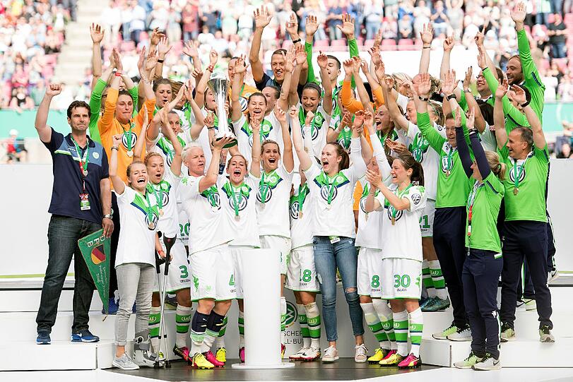 Die Wolfsburger Spielerinnen posieren mit dem DFB-Pokal für das offizielle Mannschaftsfoto.