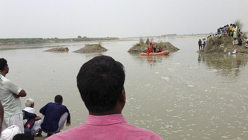 Dorfbewohner haben sich nach einem Bootsunfall in Baghpat am Yamuna-Fluss knapp 50 Kilometer nördlich der Hauptstadt Neu Delhi versammelt. Dorfbewohner haben sich nach einem Bootsunfall in Baghpat am Yamuna-Fluss knapp 50 Kilometer nördlich der Hauptstadt Neu Delhi versammelt.