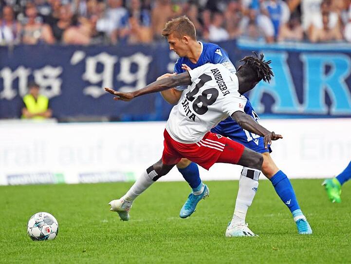Der Karlsruher Marvin Wanitzek (r) und der Hamburger Bakery Jatta kämpfen um den Ball. Foto: Uli Deck/Archivbild