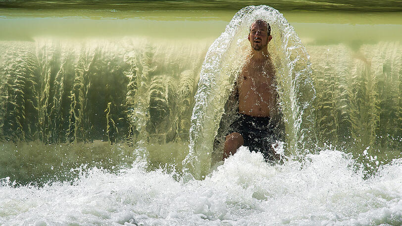Kühler Kopf trotz Hitze &ndash; Michael genießt die kalte Dusche am kleinen Wasserfall im Eisbach im Englischen Garten.