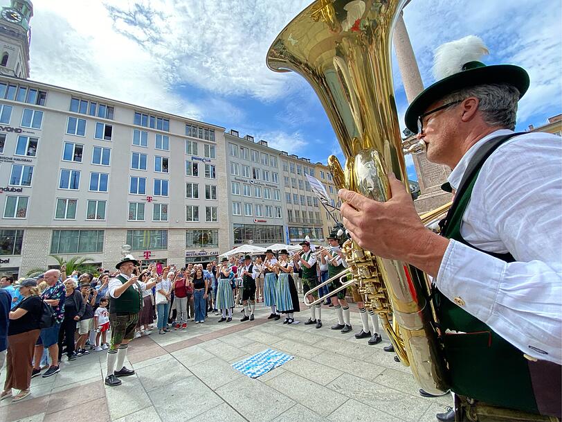 Die Neubiberger Blasmusik spielt die Olympia-Fanfare von 1972, w&auml;hrend am Marienplatz das Banner ausgebreitet wird.