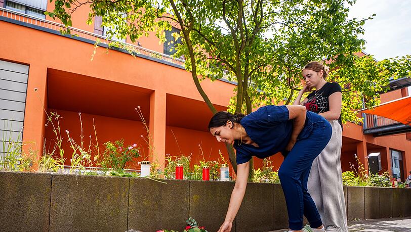 Menschen kommen vorbei und legen Blumen ab.