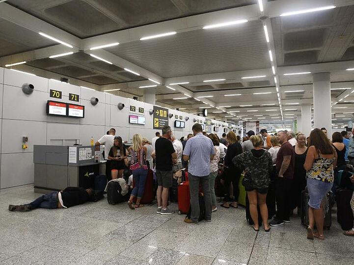 Gestrandete Urlauber stehen in einer Schlange am Flughafen von Palma de Mallorca.