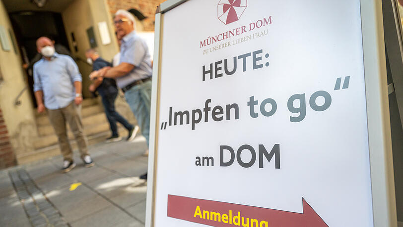 Ein Schild mit der Aufschrift "Heute: Impfen to go am Dom" steht vor der Münchner Frauenkirche. (Symbolbild)