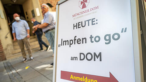 Ein Schild mit der Aufschrift "Heute: Impfen to go am Dom" steht vor der Münchner Frauenkirche. (Symbolbild)