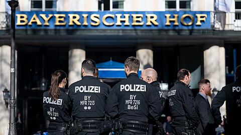 Polizistinnen und Polizisten stehen vor dem Hotel Bayerischer Hof.