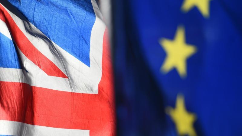 Eine Flagge der Europäischen Union und eine Flagge von Großbritannien wehen vor dem Parlament in Westminster.