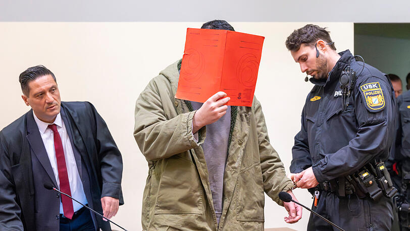 Prozessauftakt: Der Angeklagte Farhad N. wird in den Prozesssaal gef&uuml;hrt. Links steht sein Anwalt &Ouml;mer Sahinci.