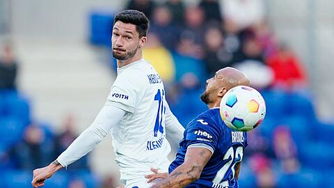 Heidenheims Tim Kleindienst (l) setzt sich im Kopfballduell gegen Hoffenheims John Anthony Brooks durch.