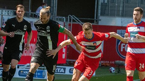 Heidenheims Jan Schöppner (r) und Sandhausens Dennis Diekmeier versuchen an der Seitenlinie den Ball zu erlaufen.