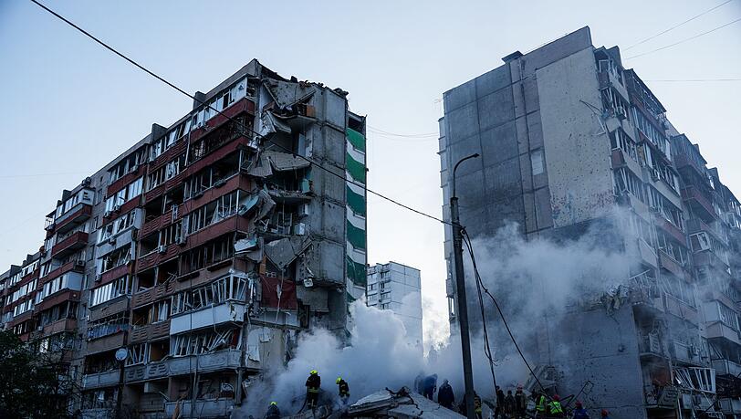 In den Tr&uuml;mmern eines bei einem russischen Angriff teils zerst&ouml;rten Hauses suchen Helfer nach Versch&uuml;tteten.