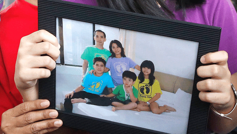 Eine Frau hält auf dem Flughafen von Surabaya ein Foto der Familie Tanus in die Kamera. Herumanto Tanus war mit seiner Frau und den beiden Söhnen an Bord von AirAsia-Flug QZ8501. Eine Frau hält auf dem Flughafen von Surabaya ein Foto der Familie Tanus in die Kamera. Herumanto Tanus war mit seiner Frau und den beiden Söhnen an Bord von AirAsia-Flug QZ8501.