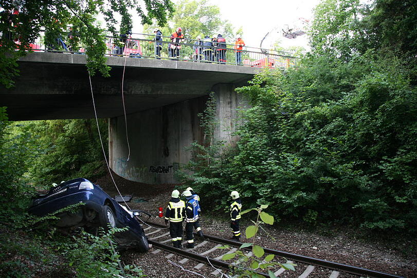 Furchtbarer Unfall im Landkreis Altötting: Ein PKW fliegt von einer Brücke herunter und knallt auf das Gleisbett. Drei junge Menschen kommen schwer verletzt in die Klinik.