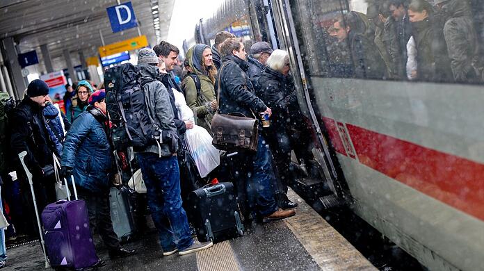 Reisende drängen sich zur Weihnachtszeit in einen Zug - ein typisches Bild im Vorfeld der Feiertage.