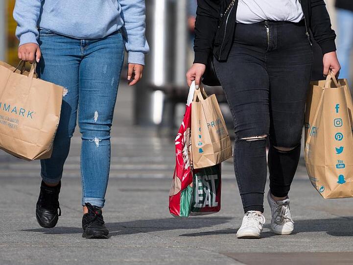 Zwei Frauen mit Einkaufstaschen der Modekette Primark flanieren in Dresden.