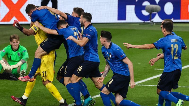 Italiens Spieler jubeln nach dem gewonnen Elfmeterschießen mit ihrem Torhüter Gianluigi Donnarumma. Hinten sitzt Englands Keeper Jordan Pickford. Italiens Spieler jubeln nach dem gewonnen Elfmeterschießen mit ihrem Torhüter Gianluigi Donnarumma. Hinten sitzt Englands Keeper Jordan Pickford.