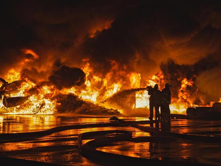 Feuerwehrleute löschen eine brennende Firmenhalle in Lauingen. Foto: Dennis Straub/Ostalb Network/dpa