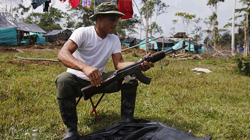 Ein Kämpfer der FARC reinigt in einem Camp in La Camerlita bei Puerto Asis seine Waffe.