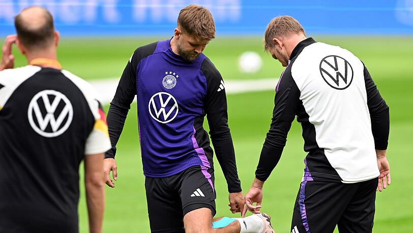Niclas Füllkrug (M) nach seinem vergeblichen Härtetest beim Abschlusstraining im Gespräch mit Bundestrainer Julian Nagelsmann (r).