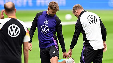 Niclas Füllkrug (M) nach seinem vergeblichen Härtetest beim Abschlusstraining im Gespräch mit Bundestrainer Julian Nagelsmann (r).