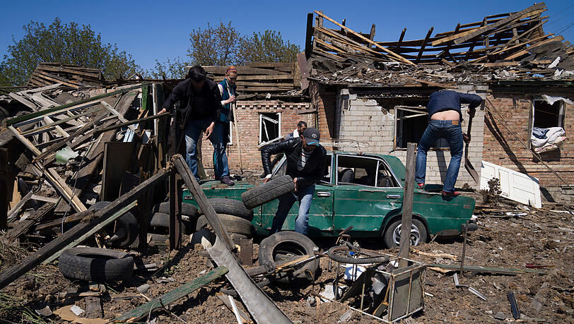 Einwohner entfernen Trümmer vor einem Haus nach einem russischen Luftangriff in Bachmut in der Oblast Donezk in der Ostukraine.