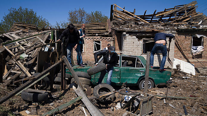 Einwohner entfernen Trümmer vor einem Haus nach einem russischen Luftangriff in Bachmut in der Oblast Donezk in der Ostukraine.