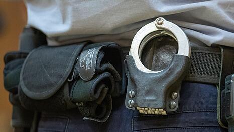 Handschellen stecken in der Gürtelhalterung eines Justizbeamten.