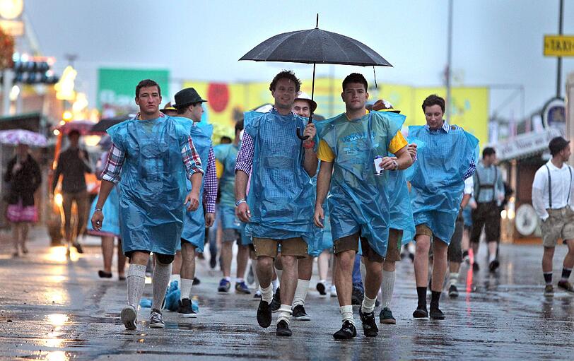 Trotz Sauwetter und Regen kamen viele auf die Wiesn. Das nasskalte Wetter des ersten Wiesntags ließ viele Besucher zum Schirm greifen - oder zum Taschentuch.
