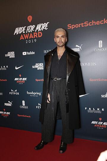 Bill Kaulitz im düsteren Outfit auf den Roten Teppich.