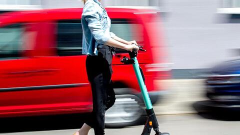 Eine junge Frau unterwegs mit einem E-Scooter in Hannover.