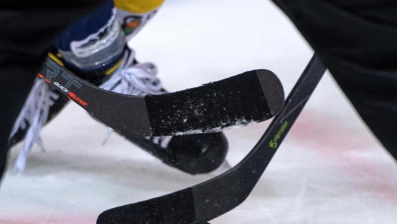 Mehrere Eishockeyspieler kämpfen um den Puck.