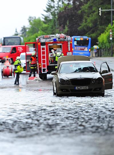 Ein Auto steht am Donnerstag in München in einer S-Bahn-Unterführung im Wasser und muss von der Feuerwehr geborgen werden.